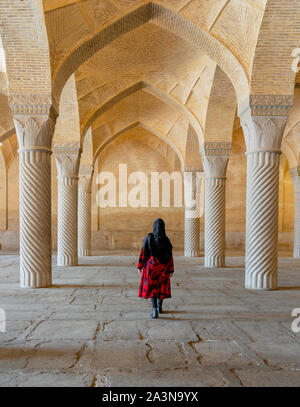 Shiraz, Iran - 2019-04-08 - Femme promenades par colonnes cannelées de mosquée Vakil. Banque D'Images