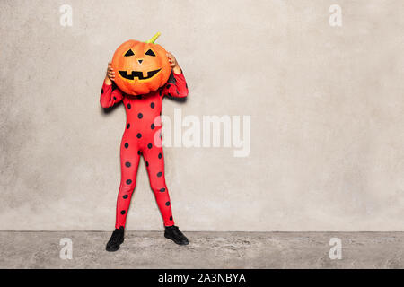 Fille en costume de coccinelle à tête de citrouille grande Banque D'Images