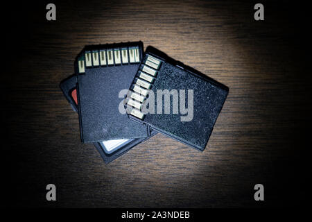 Cartes de données SD sur le bureau, sous lumière ronde comme si découvert sous enquête de lampe de poche. Banque D'Images