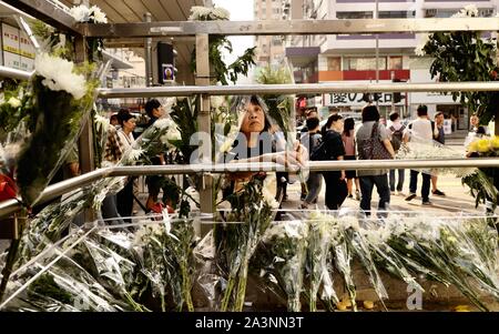 Hong Kong, Chine. 9 octobre, 2019. Une femme offre des chrysanthèmes blancs, un symbole de deuil dans la culture chinoise, à l'extérieur de la station MTR Prince Edward où certains protestataires sont soupçonnés d'être "tué" par la police anti-émeute dans la soirée du 31 août au cours de violentes manifestations. De nombreux manifestants ont subi des blessures graves à la suite d'un usage excessif de la force de police. Credit : Liau Chung-ren/ZUMA/Alamy Fil Live News Banque D'Images