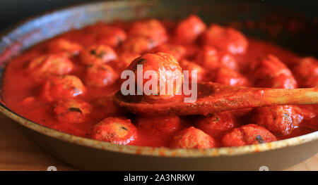 La cuisine italienne. Des boulettes à la sauce tomate dans une casserole sur fond sombre. Banque D'Images