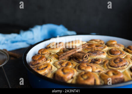 Tarte à la cannelle avec du sirop de sucre dans la casserole de vintage sur fond noir Banque D'Images