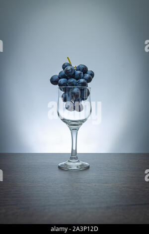 Idée conceptuelle de raisins dans le verre de vin comme matières premières au lieu de produit final Banque D'Images