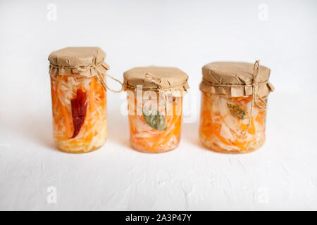 Trois pots de choucroute et de carottes dans son jus avec des épices, table en bois blanc. traditionnelle préparée, fermentées plat de la Russie et l'Allemagne. Banque D'Images