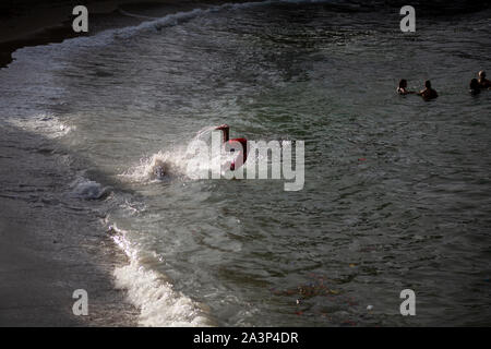 Un jeune homme passe dans l'eau à une plage à Gibara, une municipalité située dans l'Est de Cuba. Banque D'Images