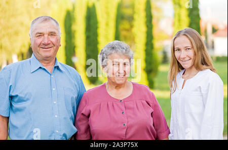 Vieux couple heureux avec leur soignant dans la nature Banque D'Images