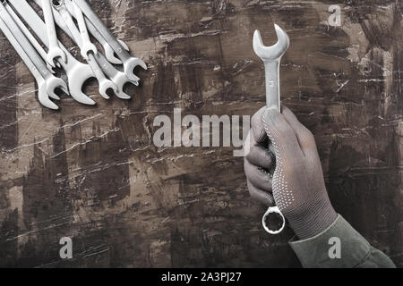 Homme main dans la main est titulaire d'une clé dynamométrique. Clés. De nombreuses clés. Contexte industriel. Ensemble d'outil clé de l'équipement. Jeu de clés dans différentes tailles sur Banque D'Images