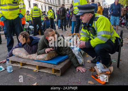 Londres, Royaume-Uni. 9 octobre 2019. Avertir la police rebelles assis sur Horse Guards Rpad ils seront arrêtés à moins qu'ils se déplacent. Extinction Rebellion rébellion internationale à Westminster l'occupation continue, avec la police qui les oblige à certains endroits, quelques tentes et décisions trashing plus d'arrestations, mais il n'y avait toujours pas de trafic dans des endroits clés et d'ateliers et d'autres événements se sont poursuivies. XR exiger du gouvernement dire la vérité sur le climat et l'urgence écologique. Crédit : Peter Marshall/Alamy Live News Banque D'Images