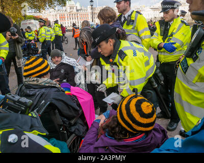 Londres, Royaume-Uni. 9 octobre 2019. Avertir la police rebelles assis sur Horse Guards Rpad ils seront arrêtés à moins qu'ils se déplacent. Extinction Rebellion rébellion internationale à Westminster l'occupation continue, avec la police qui les oblige à certains endroits, quelques tentes et décisions trashing plus d'arrestations, mais il n'y avait toujours pas de trafic dans des endroits clés et d'ateliers et d'autres événements se sont poursuivies. XR exiger du gouvernement dire la vérité sur le climat et l'urgence écologique. Crédit : Peter Marshall/Alamy Live News Banque D'Images