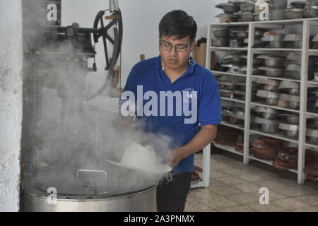 Cuisson à la vapeur et de l'élaboration des panamas traditionnels (paja toquilla) dans la région de Cuenca, Équateur Banque D'Images