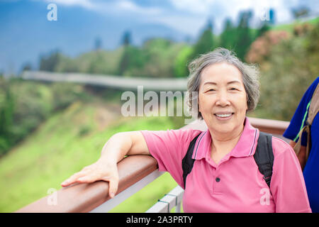 Asian Senior femme randonnée dans le parc de montagne Banque D'Images