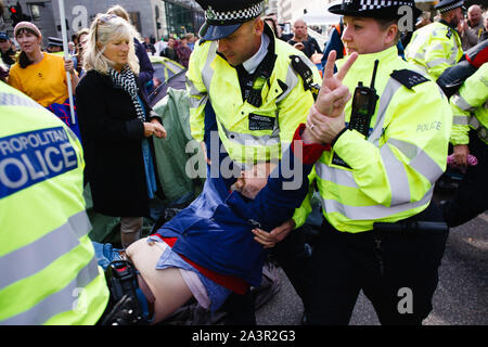 Les agents de police l'arrestation d'un membre du mouvement militant du changement climatique, l'extinction la rébellion (XR) refusant de passer d'un campement sur la rue Victoria au cours de la troisième journée de la rébellion du groupe 'International' à Londres.Des fonctionnaires de police continue d'effacer les manifestants et tentes de sites au Westminster, avec des militants ayant été averti au sujet de l'adoption d'une zone de réserve désignées autour de la Colonne Nelson à Trafalgar Square ou arrêtés. Les blocus similaires d'extinction La rébellion en avril, sur les sites, y compris Oxford Circus et de Waterloo Bridge, a vu plus de 1 000 arrêtés, une tactique promot Banque D'Images