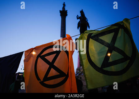 Feuilles de tissu portant le logo du changement climatique groupe activiste Extinction rébellion (XR) accrocher à une corde à linge à Trafalgar Square que l'obscurité tombe sur le deuxième jour de la rébellion du groupe 'International' à Londres.Au début de mardi soir la Police métropolitaine ont signalé qu'un total de 531 arrestations ont été effectuées au cours des deux jours de protestation dans la ville jusqu'à présent, avec les agents de police qui travaillent à prévenir les personnes et les tentes de plusieurs des sites pris en charge par les militants d'hier. Les blocus similaires d'extinction La rébellion en avril, sur les sites, y compris Oxford Circus et de Waterloo Bridge, s Banque D'Images