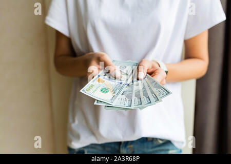 Businesswoman a obtenu l'argent comptant. Richesse et bien-être concept. Femme hands holding one hundred dollar bills. Femme en chemise blanche est titulaire d'amas de dollar Banque D'Images