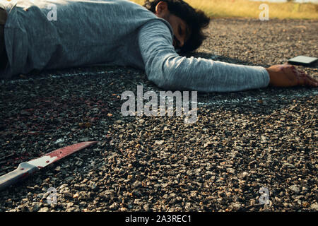 Notion de Crime scène de meurtre, Selective focus de couteau sanglant sur la route avec de la craie décrites corps mort comme arrière-plan portant sur la Banque D'Images