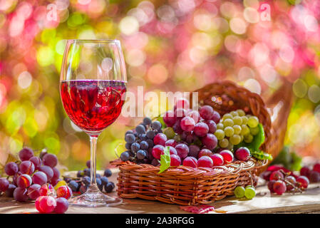 Autumn still life with ripe différents cépages et verre de vin. Derrière la magnifique bokeh d'automne. Banque D'Images