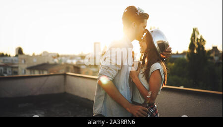 Couple flirting tout en prenant un verre sur la terrasse sur le toit Banque D'Images