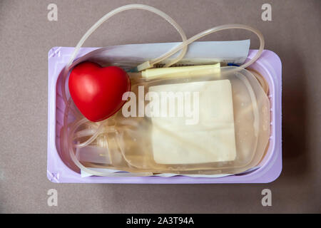 Un cœur rouge boule gonflable avec poche de sang dans le panier. Les soins de santé et de bienfaisance. Concept de don du sang Banque D'Images