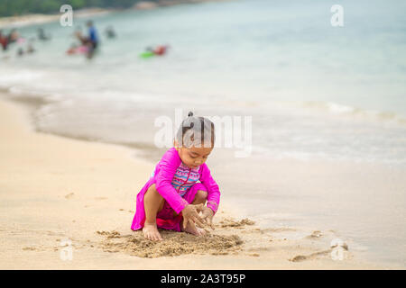 Little asian girl playing on the beach.Locations et vous détendre concept.