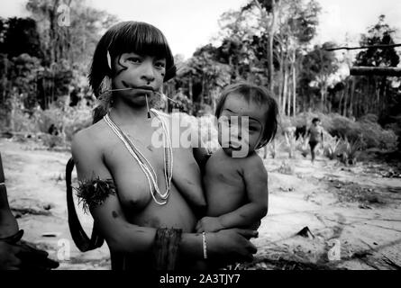 Brésil, Amazonie, Roraima : une jeune femme Yanomami avec son fils dans les bras. Banque D'Images