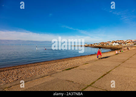 Les familles se réunissent sur la plage de Hampton et de marche de la promenade près de Herne Bay et de personnes en canoë, paddleboard et Flyboard et la lointaine Thames windfarm peut être vu, UK Banque D'Images