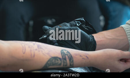 Tatoueur professionnel fait un tatouage sur la main d'un jeune homme, close-up. Artiste de tatouage tatouage tatouage fait en beauté. Processus de tatouage dans tat Banque D'Images