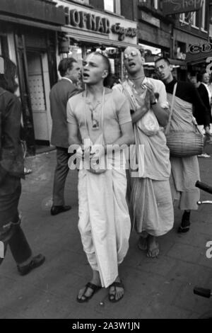 Lobpreisend trommelnd Singend, und bewegen sich durch die Jünger Hare Krishna Straßen von Amsterdam, Pays-Bas 1971. Le chant, l'éloge et de tambour Hare Krisha disciples la danse à travers les rues d'Amsterdam, Pays-Bas, 1971. Banque D'Images