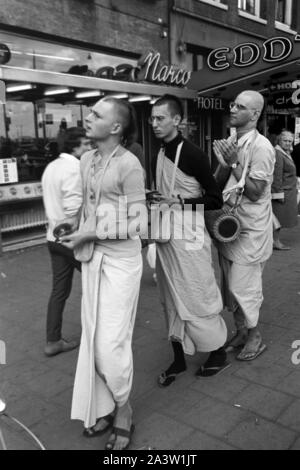 Lobpreisend trommelnd Singend, und bewegen sich durch die Jünger Hare Krishna Straßen von Amsterdam, Pays-Bas 1971. Le chant, l'éloge et de tambour Hare Krisha disciples la danse à travers les rues d'Amsterdam, Pays-Bas, 1971. Banque D'Images