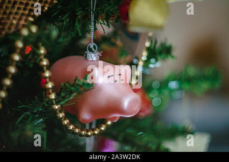 Les jouets de Noël sous la forme d'un cochon rose sur une décoration de Noël arbre de Noël. Close-up. Banque D'Images