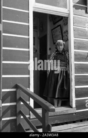 Frau in einem Hauseingang im Dorf mit Marken, feuilles en 1971. Femme dans une chambre d'entrée dans le village de l'île de Marken, Pays-Bas 1971. Banque D'Images