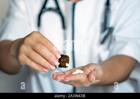 Femme médecin mains tenant la bouteille de pilules, médecin, pharmacie comprimés donner concept Banque D'Images