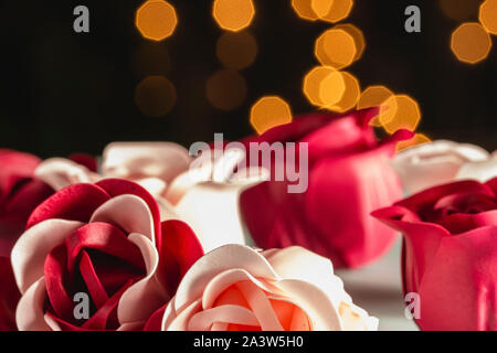 Fleurs rouges et roses roses en savon parfumé sur fond flou, copie espace libre Banque D'Images