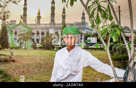 MYSURU (Mysore),KARNATAKA/Inde 13 FÉVRIER 2018-H un enfant musulman habillé en costume traditionnel se trouve dans un petit parc, en face de la mosquée qu'il att Banque D'Images