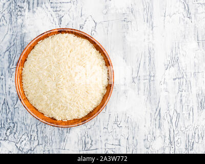 Le riz Basmati dans un saladier en bambou blanc sur fond de béton Banque D'Images