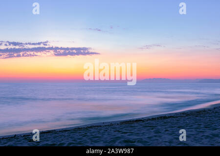 Pastel sur Ciel de coucher du soleil. Une longue exposition seascape avec orange au crépuscule. Paysage aux couleurs ciel du soir et de flou de l'eau. Italie Banque D'Images