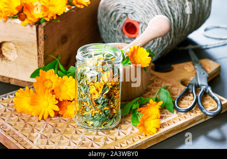 De fines herbes Calendula matériel : un pot avec marigold sec, un mortier avec bouquet de fleurs fraîches, des ciseaux et fils de lin et une boîte de médicaments ma Banque D'Images