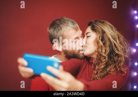 Faire un couple heureux avec selfies mobile smartphone app - Les jeunes amoureux s'amusant en tenant avec téléphone appareil selfies Banque D'Images