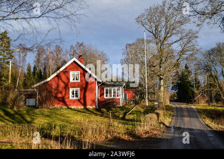 Suède : Hokerum. Paysage rural, Ulricehamn Municipalité, Vastra Sweden Comté. Maison en bois traditionnel suédois avec façades rouges et blanches sur le Banque D'Images