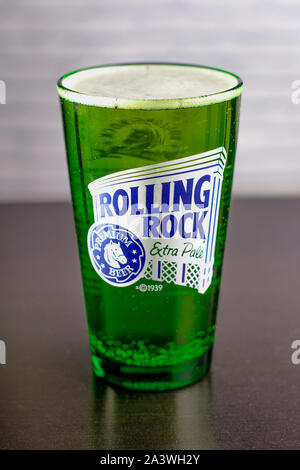 Extra Pale Rolling Rock beer bière noire sur une table avec un mur de brique vue verticale. Banque D'Images