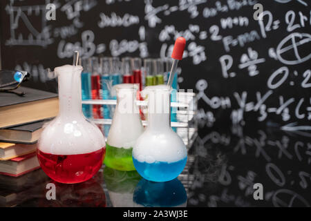 Classe 24 et tableau noir tiré de l'enseignement de la chimie avec des livres et d'instruments. L'enseignement des sciences chimiques concept. Banque D'Images