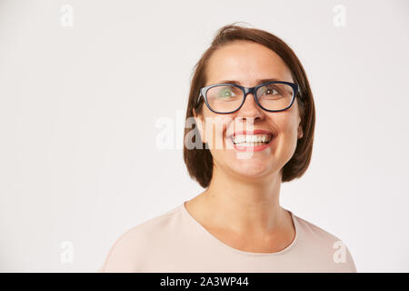 Portrait de jeune femme heureuse avec des cheveux courts et dans eyeglasses smiling contre le fond blanc Banque D'Images