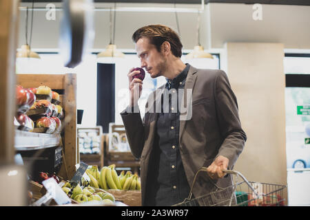 L'achat de l'acheteur mâle pommes dans un épicerie Banque D'Images