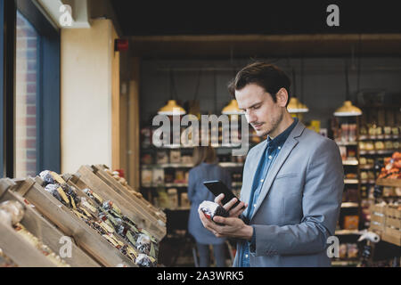 Mâle adulte Utilisation de l'auto-scan dans l'épicerie Banque D'Images