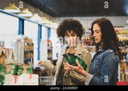 Les jeunes femelles adultes food shopping dans un magasin d'alimentation Banque D'Images