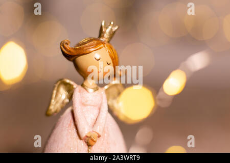 Sur le thème de Noël Décoration figurines. Statuette de un ange de Noël. Décoration d'arbre de Noël. Décor de fête, chaud bokeh lights Banque D'Images