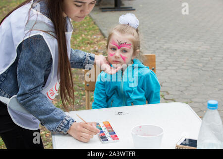 Le Bélarus, la ville de Gimel, Juillet 03, 2019. Festival de la jeunesse.Petite fille dessiner la peinture du visage Banque D'Images