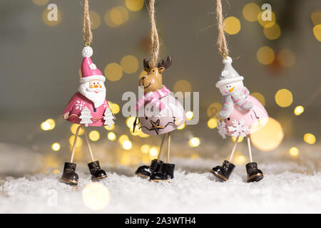 Figurines décoratives d'un thème de Noël. Ensemble de statuettes de santa, bonhomme de neige et les cerfs. Décoration d'arbre de Noël. Décor de fête, chaud bokeh lights Banque D'Images