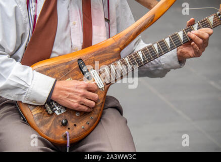 Close up d'un homme musicien ambulant jouant une guitare électrique solid body Banque D'Images