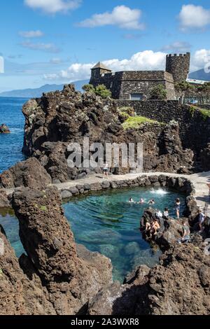 Les nageurs, les piscines naturelles dans la roche volcanique, Porto Moniz, île de Madère, Portugal Banque D'Images