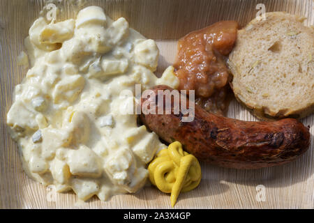 Saucisse rôti avec salade de pommes de terre, la moutarde et le pain d'une plaque en bambou n, restauration rapide pour aller sur un festival de rue, haut Vue de dessus Banque D'Images